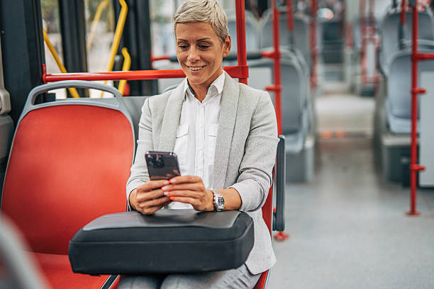 istock Businesswoman using smartphone while riding bus to work 2235197040