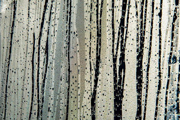Raindrops of all sizes accumulating on the window glass