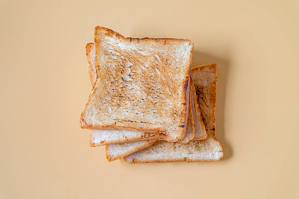 Slices of freshly toasted bread on color background.