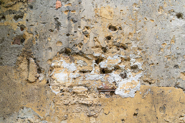istock Wall surface exhibiting signs of aging, with peeling paint, visible layers, and underlying stone texture 2235213375