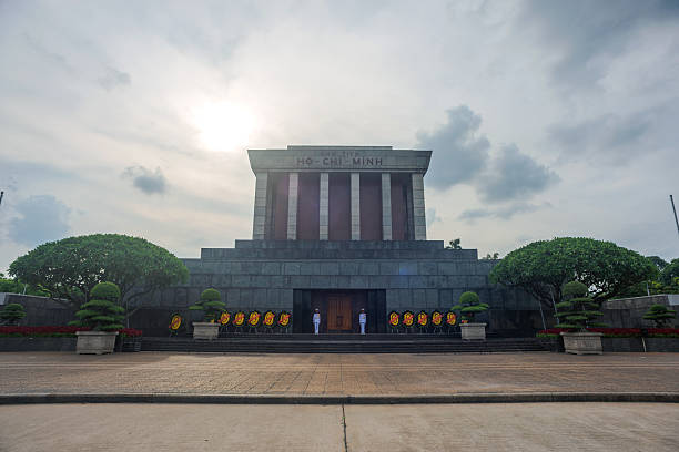 This impressive photograph captures a landscape monumental view of Ho Chi Minh Mausoleum in Hanoi, showcasing the grand scale of the mausoleum within its expansive plaza. The image emphasizes symmetry, architectural majesty, and the solemn atmosphere of this iconic Vietnamese landmark. Surrounded by greenery and wide open spaces, the photograph evokes national pride, historical significance, and the cultural heritage of Vietnam. Perfect for editorial, travel, or cultural projects.