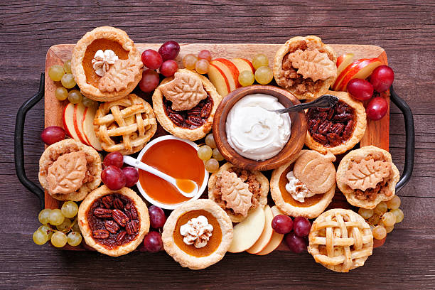 Autumn pie theme dessert board. Top view against a dark wood background.