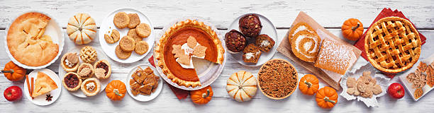 istock Autumn desserts table scene. Above view over a white wood banner background. 2235221924