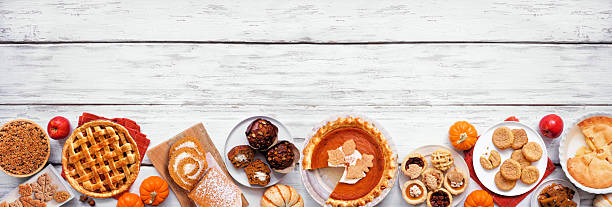 istock Autumn desserts bottom border. Top view over a white wood banner background. 2235221925