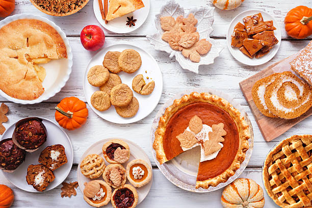 Autumn desserts table scene. Above view over a white wood background.