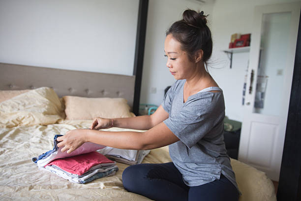 istock Asian Woman Folding Clothes After Laundry 2235223826
