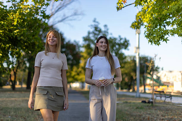 istock Two friends walking in the park at sunset 2235228864