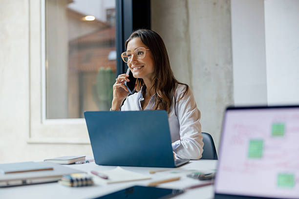 istock A Professional Woman Engaged in Remote Work While Using a Laptop and a Phone Device 2235230789