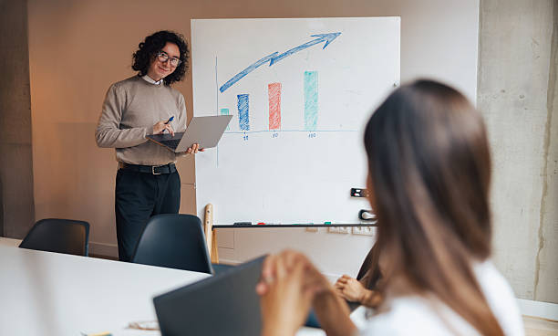 istock Business Presentation with a Growth Chart and an Engaged Audience actively participating 2235233150