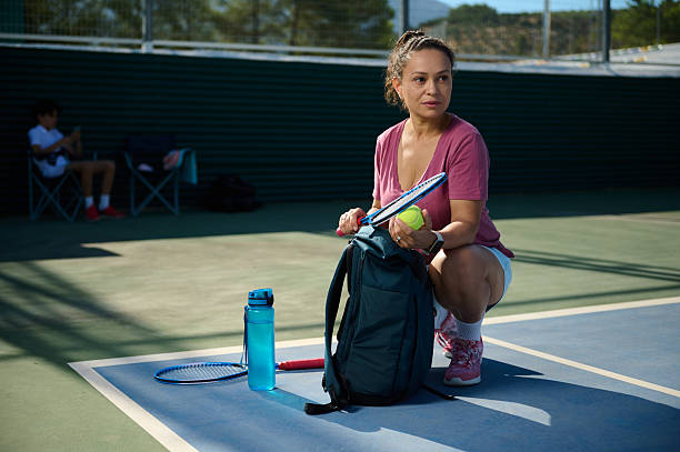 istock Woman Preparing for Tennis Match Outdoors Under Sunny Conditions 2235233155