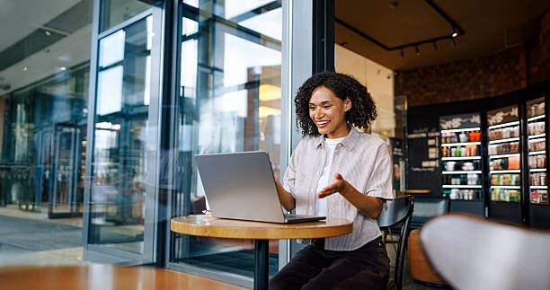 istock A young woman is engaged with her laptop while sitting down in a chic modern cafe setting 2235233594