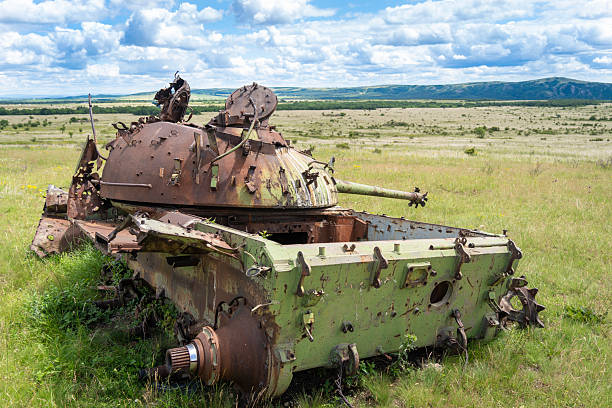 istock Old destroyed Russian T-54 tank on a grassy field 2235242423