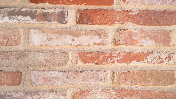 istock Close-up of rustic red brick wall with weathered texture 2235243288