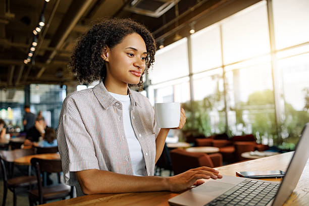 istock A Young Woman Engaged in Her Work on a Laptop While Sitting Comfortably in a Cozy Cafe Setting 2235246202