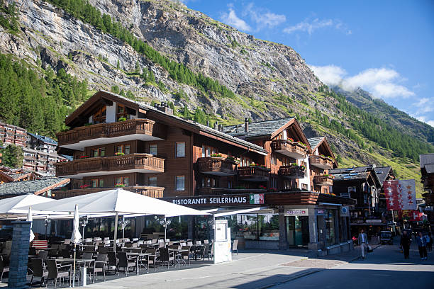 Zermatt, Switzerland - July 9, 2025: Pedestrians stroll historic Bahnhofstrasse. The street is considered Zermatt’s main shopping district.