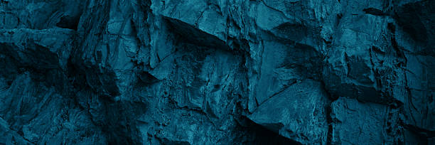 istock Black dark blue turquoise stone rock texture background. Toned rocky surface mountain. Close-up. Nature. For design. Wide banner. Panoramic. 2235248999