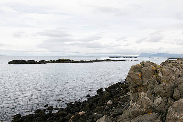 istock Peaceful rocky coastline view under cloudy skies in Iceland with distant islands 2235250388