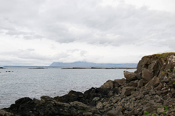 istock Rocky coastline with ocean views and distant mountains under a cloudy sky in Iceland 2235250483