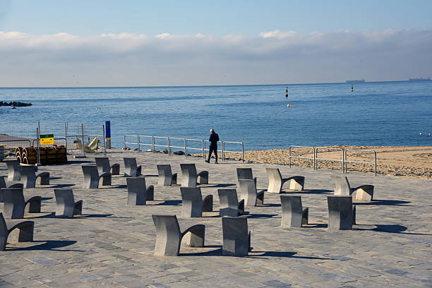 Barcelona coastline with some huge cargo ships at the horizon over seas. Captured during a sunny day on spring season.