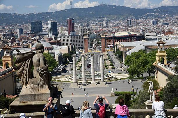 Tourists  looking to the wonderful City of Barcelona and taking photos. Captured on a sunny day during spring season.