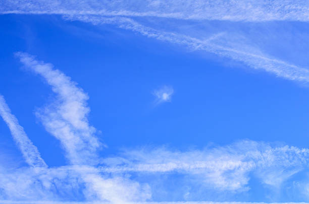 Morning sky with airplane vapor trails and soft clouds creating scenic view