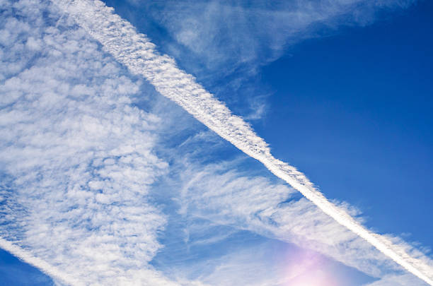 istock Morning sky with scattered clouds and visible airplane contrails above horizon 2235253119