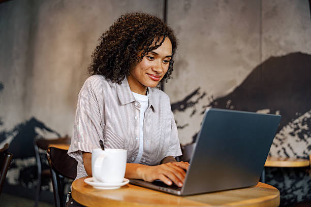 istock A young woman is focused on her laptop in a modern cafe, creating a productive work atmosphere 2235253827