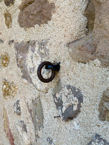 istock Old stone wall with rusty iron ring detail 2235253886