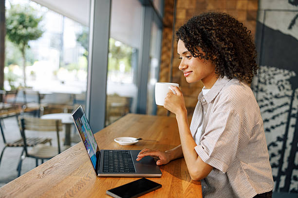 istock A Young Woman is Enjoying Her Coffee While Working on Her Laptop in a Cozy Cafe Setting 2235255136