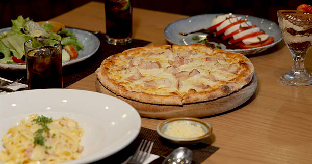 Italian cuisine dinner spread with pizza, pasta, salad, desserts on