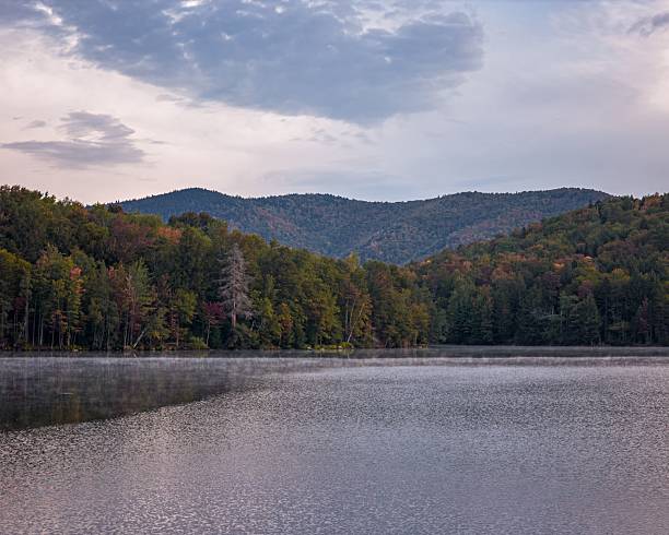 istock Serene lake landscape with mist and green hills. 2235258661