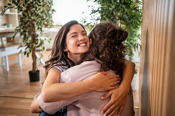 istock Two young women are hugging at home with joy 2235269741