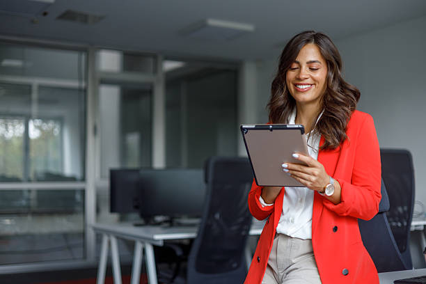 istock Professional female entrepreneur using digital tablet, working at sleek desk in contemporary workspace, embodying corporate success 2235270629