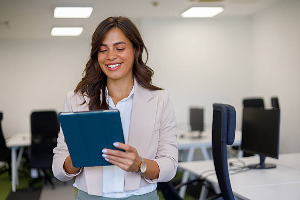 istock Businesswoman smiles while using a digital tablet in a modern office setting, enjoying the convenience of technology 2235272880