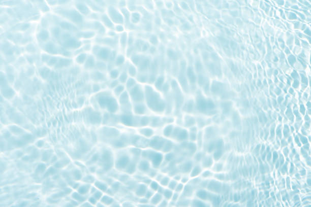 istock Blue water with ripples on the surface. Defocus blurred transparent blue colored clear calm water surface texture with splashes and bubbles. Water waves with shining pattern texture background. 2235273747