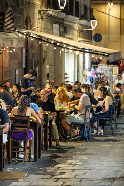 Cagliari, Sardinia, Italy Aug 8, 2025 People eating at an outdoor restaurant on the street in the historic old town.,