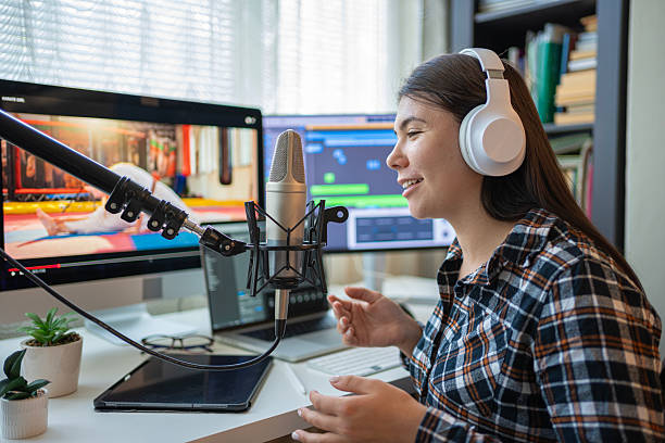 istock College Radio. Student Recording Podcast In Professional Studio Using Microphone & Headphones 2235275806