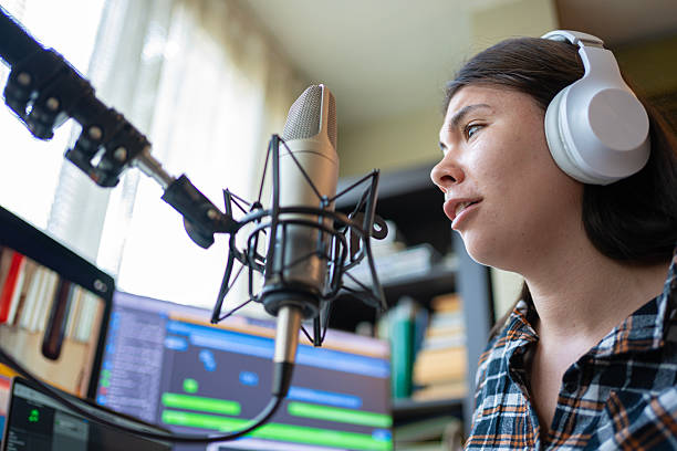 istock College Radio. Student Recording Podcast In Professional Studio Using Microphone & Headphones 2235275859