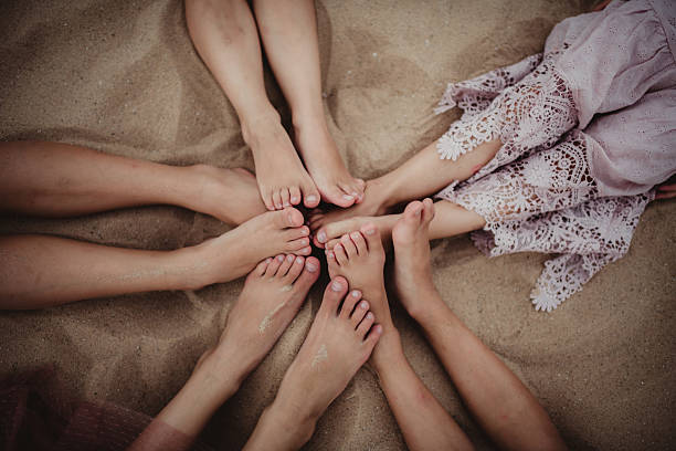 Children with bare feet touching on the sand beach