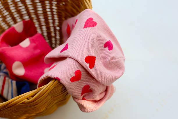 istock Mixed colorful socks with polka dot, stripe, and heart patterns in a laundry basket. 2235289762