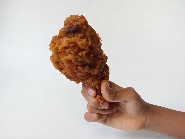 Kids Hand hold fried chicken isolated on white background. Chicken drumstick which is kids and adults favorite