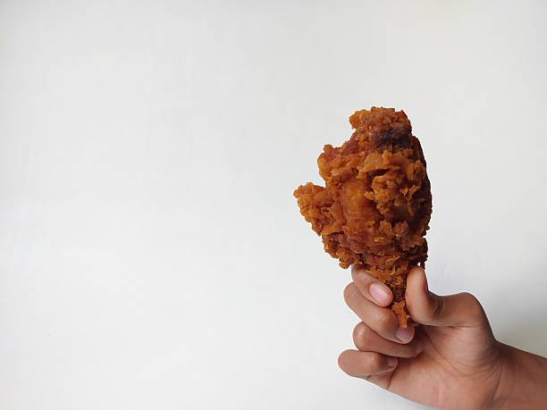 Kids Hand hold fried chicken isolated on white background. Chicken drumstick which is kids and adults favorite