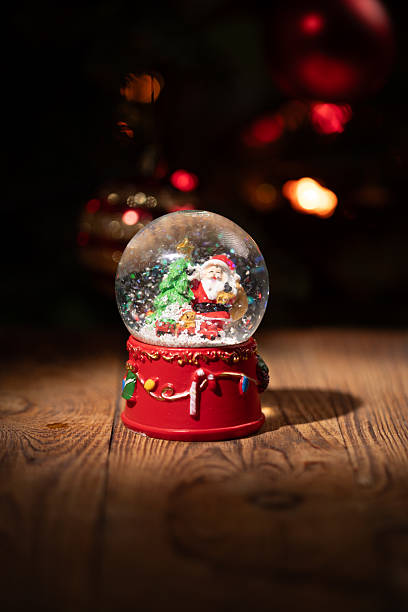 istock Joyful Christmas Celebration With a Snow Globe Featuring Santa and a Christmas Tree 2235294105