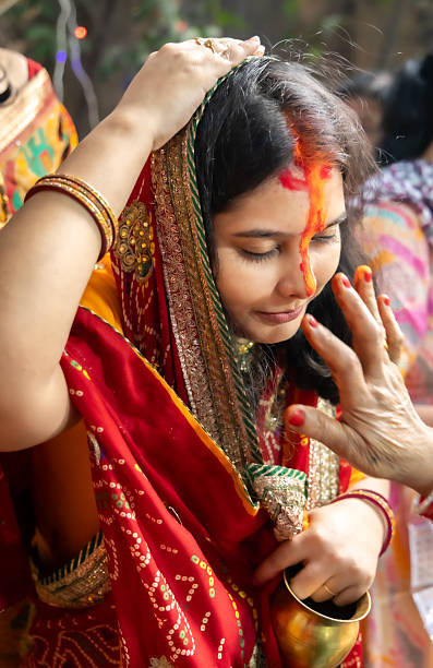 sacred sindoor offering ritual by devotee at chhath puja celebration