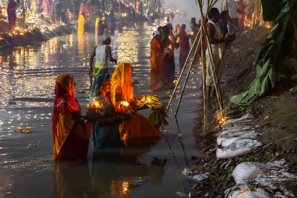 hindu devotee performing chhath puja prayers at riverbank in foggy morning image is taken at janakpuri new delhi on Nov 08 2024.