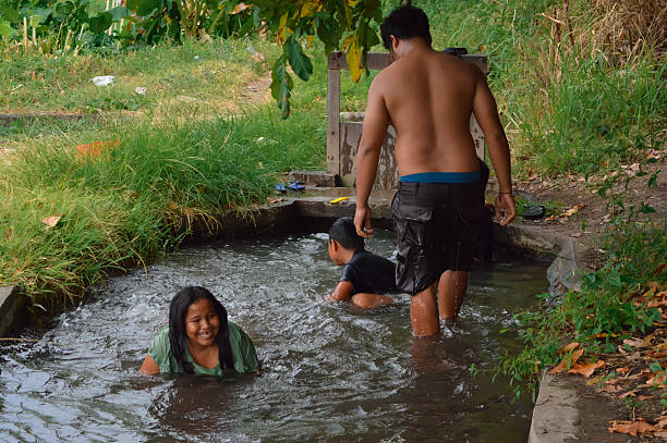 istock Father walking with wet clothes while children play in water 2235302788