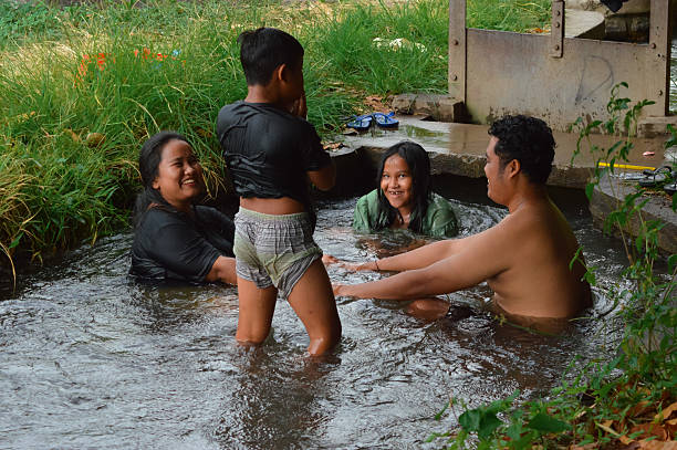 istock Boy stands after dive while sister smiles in countryside water 2235302953