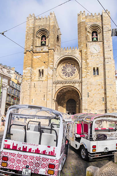 Tuk tuk are parked in front of the Cathedral of Saint Mary Major - Sé de Lisboa, the oldest church in the city, built in 1147 and survived many earthquakes over the centuries