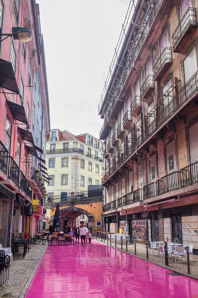 People strolling in the Rua Nova do Carvalho in Lisbon, a small pedestrian street better known as “Pink Street”, since the pavement was painted pink in 2013