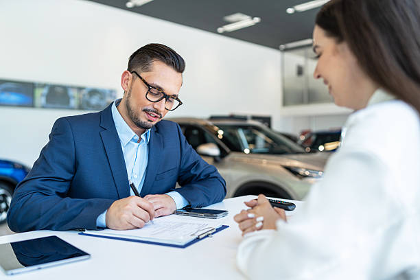 istock Car salesman explaining vehicle features to customer in showroom 2235310859